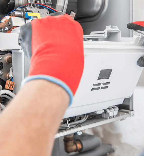Gas Engineer King's Lynn carrying out a professional boiler service with the front panel removed to inspect internal components of a modern gas boiler.