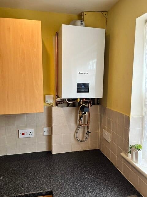 Central Heating Service King's Lynn with a professionally installed Glow-worm gas boiler in a modern kitchen featuring neat copper pipework and a magnetic system filter.