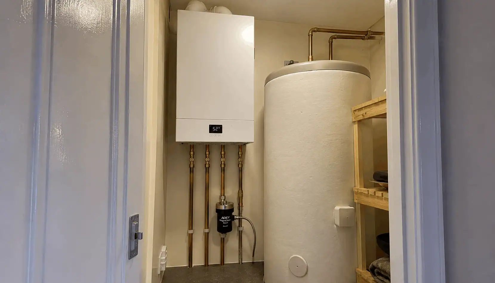 New Boiler Cost 2026: Prices from £1,799 +VAT in King’s Lynn, featuring a modern system boiler and hot water cylinder installation with a magnetic filter, neatly fitted in an airing cupboard by Delta Gas Installations.