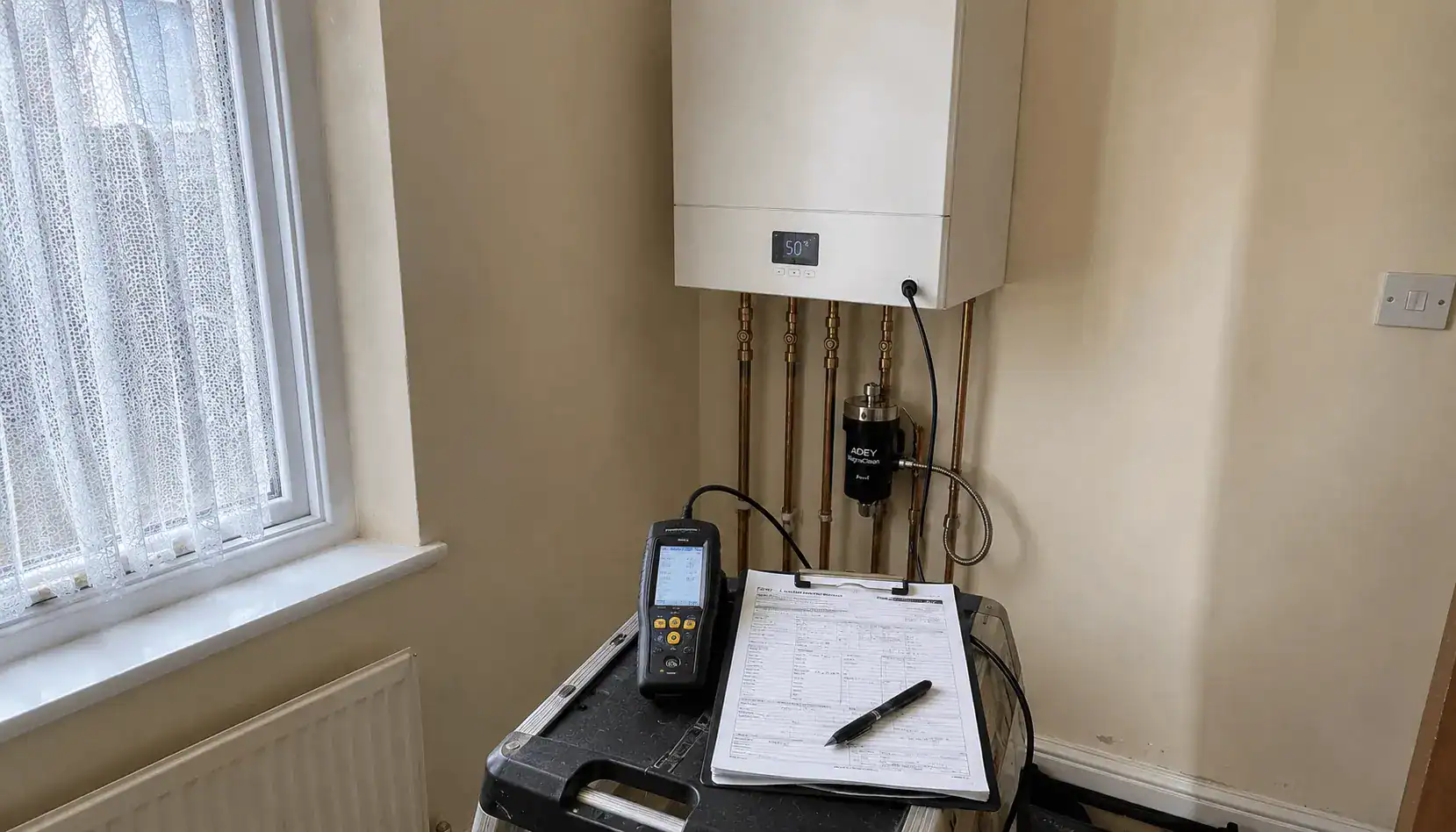Landlord Gas Safety Certificate in King's Lynn being completed during a Gas Safe boiler inspection with flue gas analyser and CP12 paperwork in a rental property.