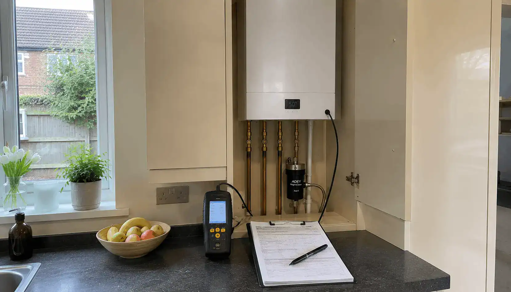 Landlord Gas Safety Certificate in King's Lynn being completed during a Gas Safe inspection of a wall-mounted boiler in a rental property's kitchen.