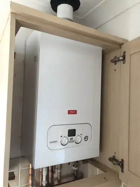 Boiler Supplier King's Lynn installing a Main gas boiler neatly fitted inside a kitchen wall cupboard with tidy copper pipework.